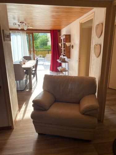 - un salon avec un canapé en cuir et une salle à manger dans l'établissement Appartements en Montagnes, à Aime La Plagne