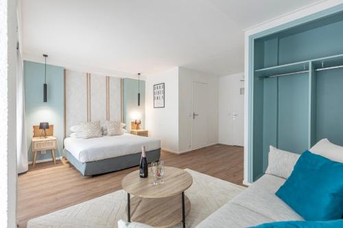 a bedroom with a bed and a couch and a table at Le Bastille By Sweett in Paris