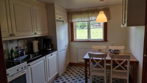 a kitchen with a table and chairs and a sink at Saltögården in Strömstad