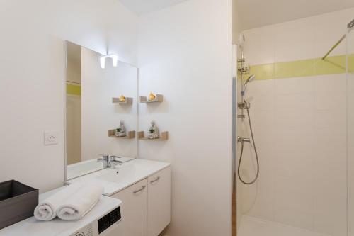 une salle de bain blanche avec un lavabo et une douche dans l'établissement Akoya Urban Loft - Duplex dernier étage terrasses, à Rennes