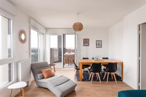 un salon avec une chaise et une table dans l'établissement Akoya Urban Loft - Duplex dernier étage terrasses, à Rennes