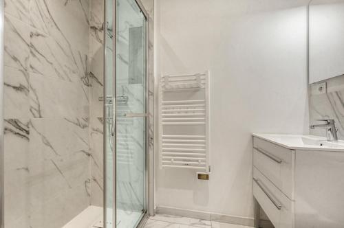 une salle de bain avec une douche en verre et un lavabo dans l'établissement L'Atelier d'Idrac - Appt cosy pour 2p Toulouse, à Toulouse