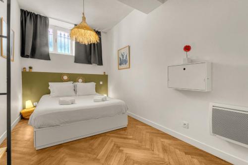 une chambre blanche avec un lit et une télévision dans l'établissement L'Atelier d'Idrac - Appt cosy pour 2p Toulouse, à Toulouse