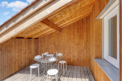 une terrasse en bois avec une table et des chaises. dans l'établissement Pinalis - Appt 4p avec terrasse à Toulouse, à Toulouse