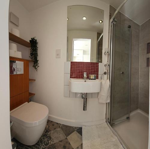 Un baño con inodoro, lavabo y ducha. en EcuaStay New Luxurious 4 Bedroom Home with Garden and parking, en Dagenham