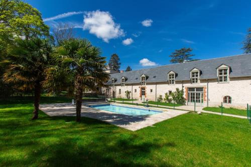 une grande maison avec une piscine dans la cour dans l'établissement Château de Conon gîte l'Orangerie, à Cellettes