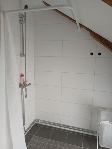 a shower stall in a bathroom with white tiles at Kungsgården BnB in Kungsgården