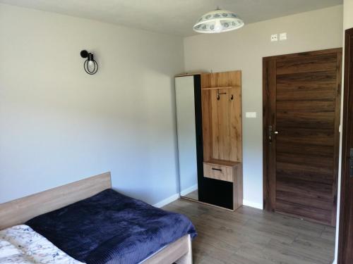 a bedroom with a bed and a wooden door at Agroturystyka Szklana Polana in Huta Szklana