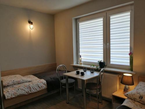 a bedroom with a table and a bed and a window at Agroturystyka Szklana Polana in Huta Szklana