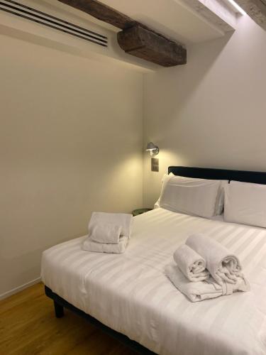 a bedroom with a white bed with towels on it at Palazzina RIVA in Venice