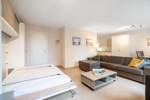un soggiorno con un divano e un tavolo di Le Cosy Miramar appartement a Blankenberge