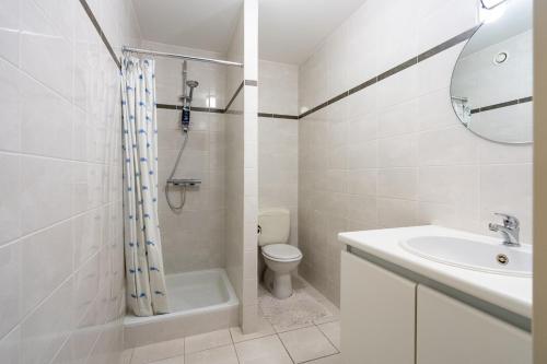 un bagno bianco con un water e un lavandino di Le Cosy Miramar appartement a Blankenberge