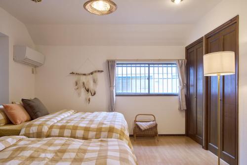 a bedroom with two beds and a window at PDO inn Sangenjaya Art residence in Tokyo