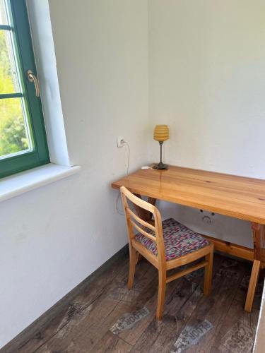 a wooden table with a chair next to a window at Siedlisko Lubie in Złocieniec