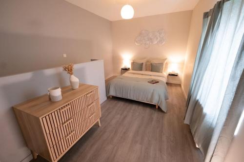 une chambre avec un lit et une commode dans l'établissement Le Cocon - Proche Gare Châteaucreux-, à Saint-Étienne