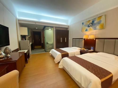 a hotel room with two beds and a television at Yinfeng Hotel Guangzhou North Station Branch, Huacheng Road Subway Station Branch in Huadu