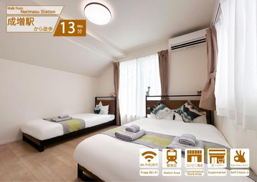 two beds in a hotel room with a price sign at nestay villa tokyo itabashi in Tokyo