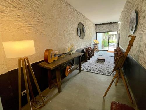 une chambre avec une table et une guitare sur le mur dans l'établissement Maison 
