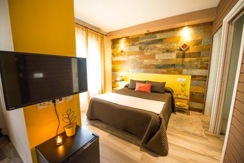 a bedroom with a bed and a flat screen tv at Mirador Messia de Leiva , Casa Geno in Segura de la Sierra