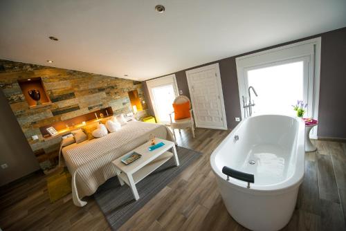 a large bathroom with a tub and a bed and a couch at Mirador Messia de Leiva , Casa Geno in Segura de la Sierra