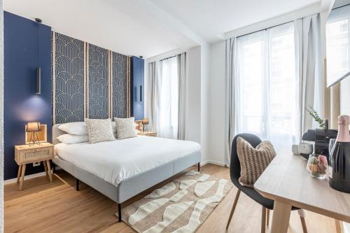 a bedroom with a king sized bed and a desk at Le Bastille By Sweett in Paris