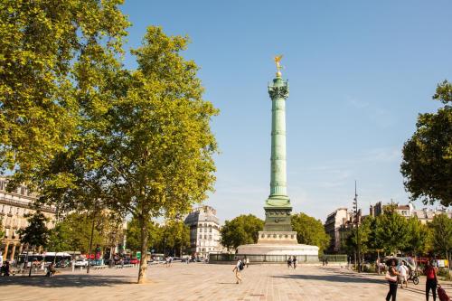 un monument dans une ville avec des gens qui se promènent autour dans l'établissement Le Bastille By Sweett, à Paris