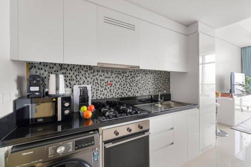 a kitchen with white cabinets and a stove top oven at FIRST CLASS Studio Luxe Living in Dubai