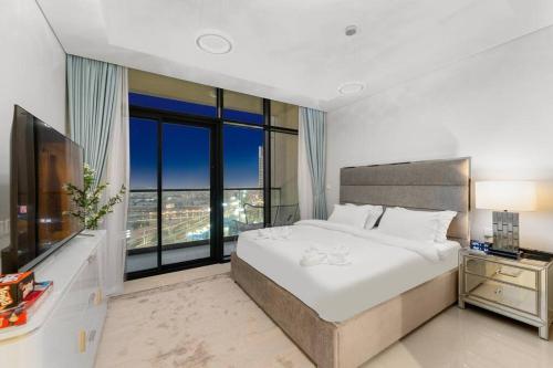 a bedroom with a large bed and a large window at FIRST CLASS Studio Luxe Living in Dubai