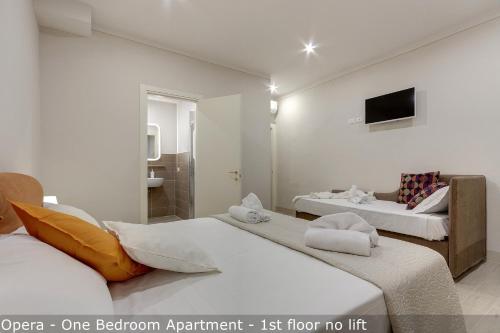 a hotel room with two beds and a tv at Opera - Sinfonia - Minuetto - Melody Apartments by Mamo Florence in Florence