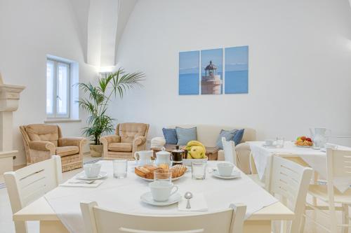 une salle à manger blanche avec des tables et des chaises blanches dans l'établissement Il cielo in una stanza B&B, à Castrignano del Capo