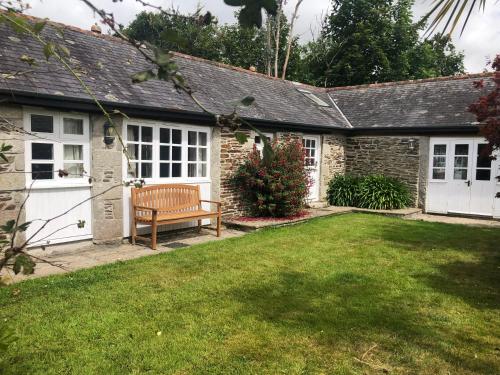 a house with a bench in a yard at Wisteria Cottage in Truro