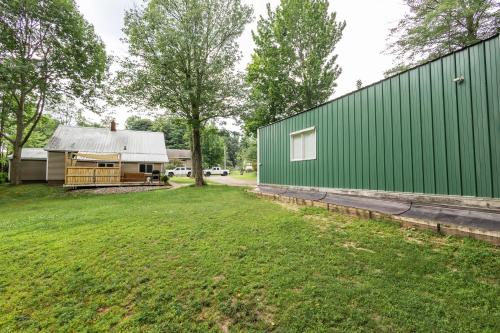 a green building next to a yard with a house at Spacious & Updated MQT Home - HotTub - Backyard in Marquette