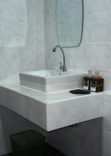 a white sink in a bathroom with a mirror at Waste Land Homestay & Resort Chiangmai in San Pa Tong