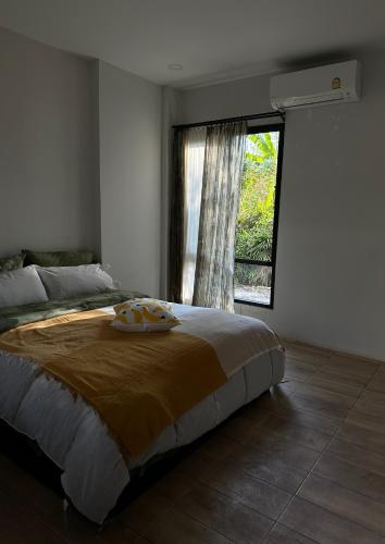 a bedroom with a large bed and a window at Waste Land Homestay & Resort Chiangmai in San Pa Tong