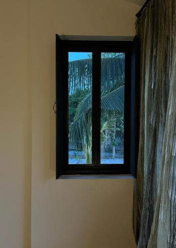 a window in a room with a curtain at Waste Land Homestay & Resort Chiangmai in San Pa Tong