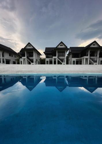 a pool of water in front of some houses at Waste Land Homestay & Resort Chiangmai in San Pa Tong
