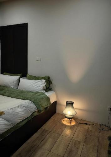 a bedroom with two beds and a lamp on the floor at Waste Land Homestay & Resort Chiangmai in San Pa Tong