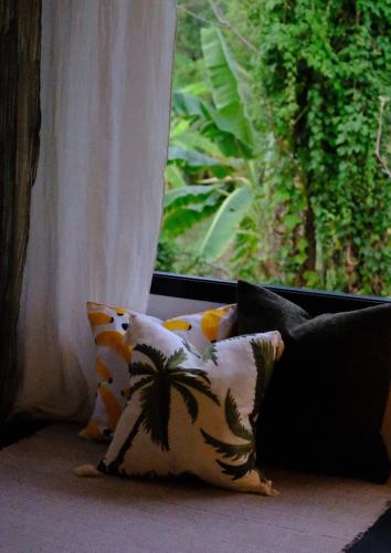 a group of pillows sitting in front of a window at Waste Land Homestay & Resort Chiangmai in San Pa Tong