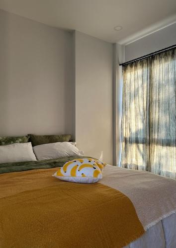 a bedroom with a bed with a pillow on it at Waste Land Homestay & Resort Chiangmai in San Pa Tong