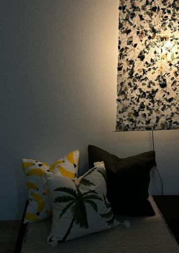 a room with a couch with pillows and a lamp at Waste Land Homestay & Resort Chiangmai in San Pa Tong