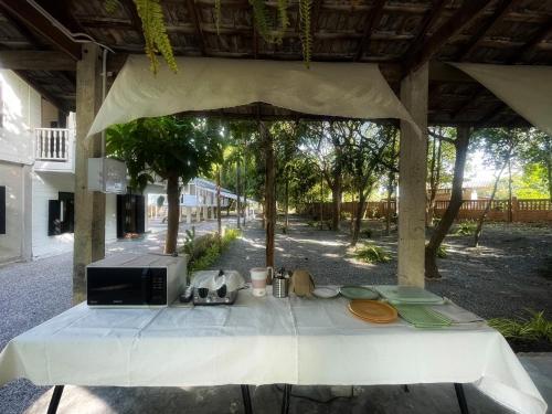 a white table with plates and a microwave on it at Waste Land Homestay & Resort Chiangmai in San Pa Tong