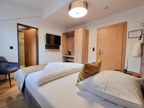 a hotel room with two beds and a tv at Belmonte Tirol - Boutique Hotel in Sillian