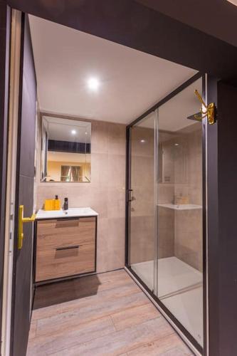 une salle de bain avec une douche en verre et un lavabo dans l'établissement Le Paris - Proche Gare Chateaucreux-, à Saint-Étienne