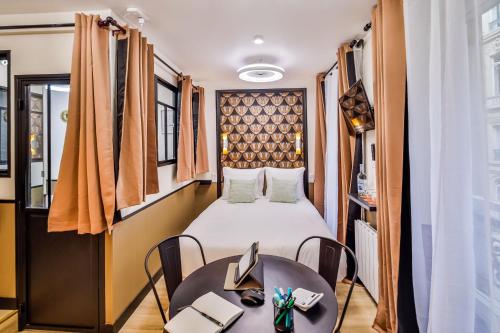 une chambre avec un lit, une table et des chaises dans l'établissement WS Louvre - Saint-Florentin, à Paris