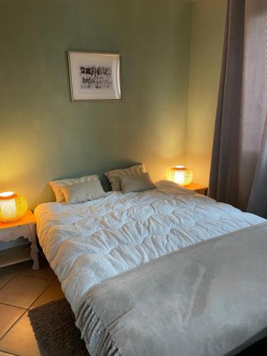 un grand lit dans une chambre avec deux lampes dans l'établissement Maison au cœur de la vallée de Haute-Tarentaise, à La Plagne Tarentaise