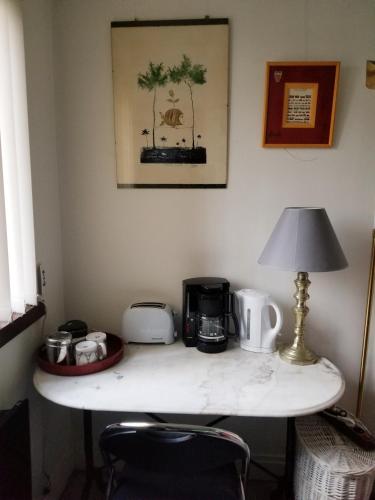 - une table avec une cafetière et une lampe dans l'établissement Chambre et salle d'eau proches du Sacré-Coeur, à Paris