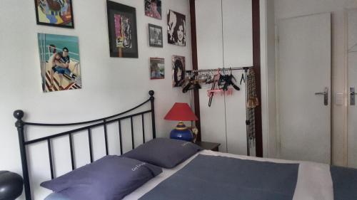 a bedroom with a bed with blue pillows and pictures on the wall at Chambre et salle d'eau proches du Sacré-Coeur in Paris