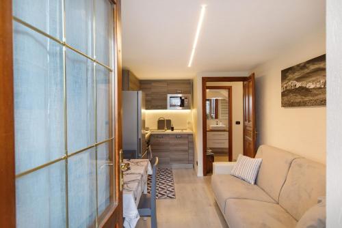 a living room with a couch and a kitchen at Casa Piertor Morgex in Morgex