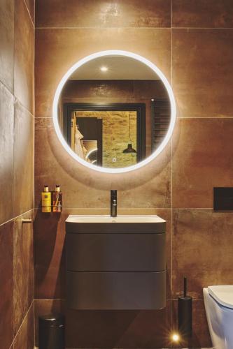 a bathroom with a sink and a mirror at The Piggery in Glastonbury
