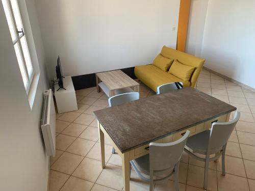 un salon avec une table, des chaises et un canapé dans l'établissement Appartement centre-ville Arles, à Arles